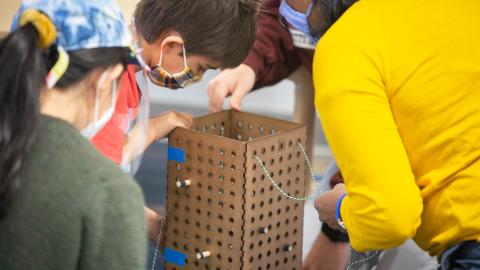 college students play with young children to test toy design