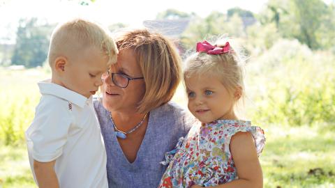 a grandmother speaks with her two grandchildren