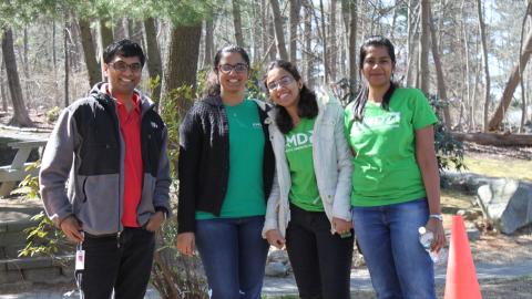 4 corporate volunteers pause their work to smile for a photo