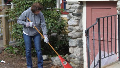 a woman rakes near a door
