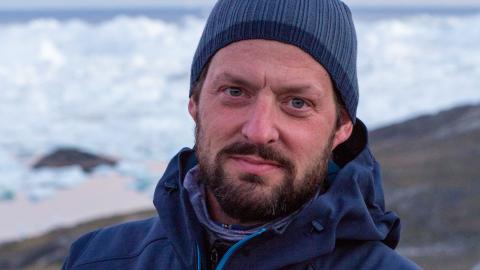 man wearing blue winter hat looking straight ahead