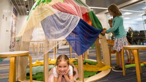 a child lays in a pretend caterpillar next