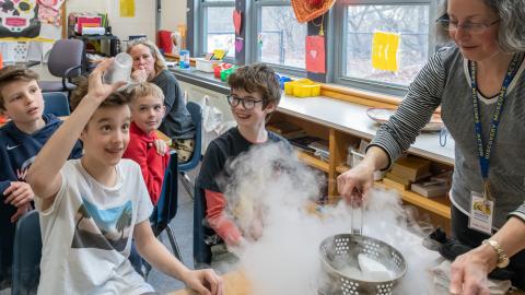a boy student dumps vapor onto his head during a science experiment