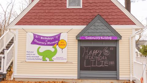 the exterior of a building with a chalkboard sign that says, "Happy Birthday Lillie"