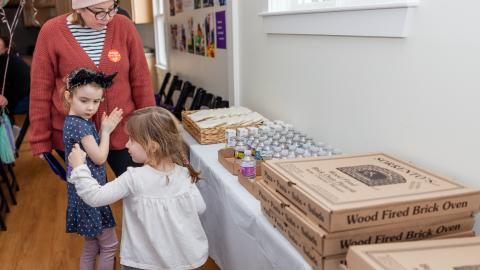 party guests help themselves to pizza on a side table