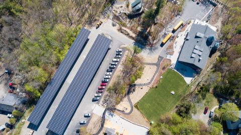 aerial view of Discovery Museum campus with two full rows of solar arrays on covered parking