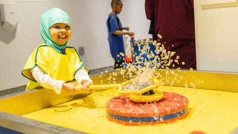 a young girl explores a water exhibit