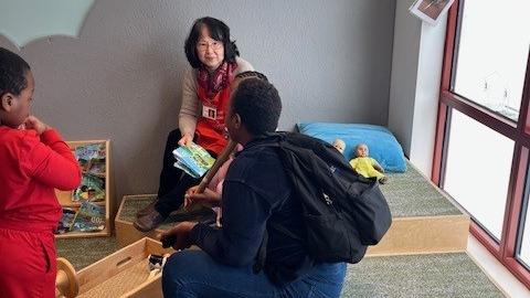 a grandparent staff volunteer speaks with parent visitors at a musum