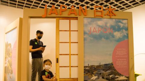 a father and son walkthrough the doorway of an exhibit of a Japanese home