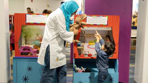 a mother and son act out a story with a puppet