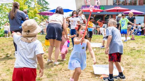 a young girl runs with a bubble wand
