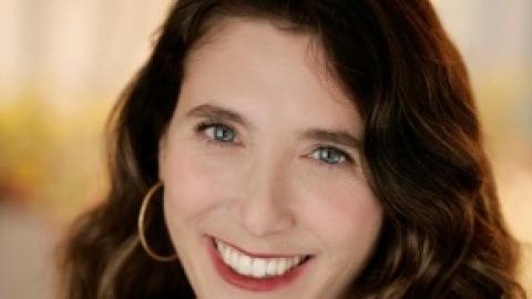 woman with wavy brown hair wearing black shirt