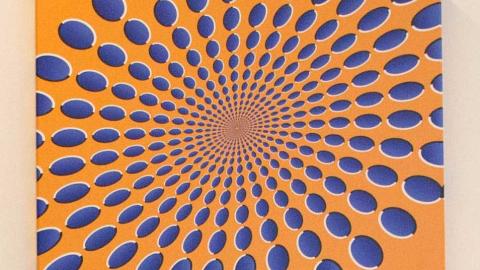 blue dots seem to swirl on an orange background
