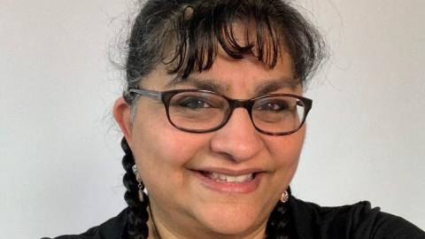 woman with glasses and bangs looking at camera