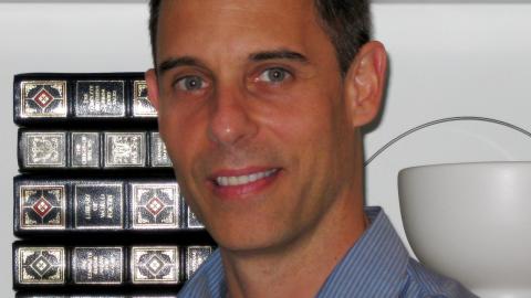 headshot photo of a man in a blue shirt