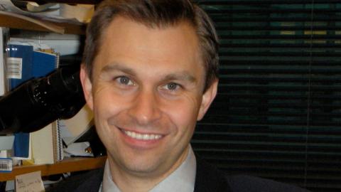 man wearing red tie looks at camera
