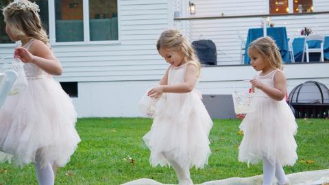 three small girls in dresses in a back yard