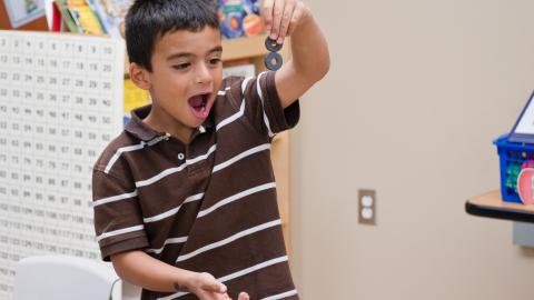 a boy's face shows surprise and delight as he experiments with magnets