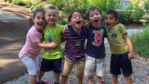 5 very excited and happy kids pose for a photo outdoors