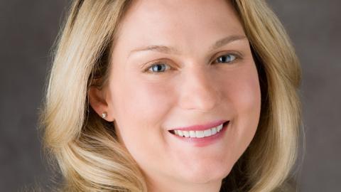 headshot photo of a blonde woman in a black shirt