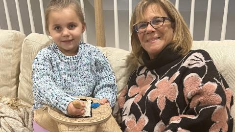 a grandmother and granddaughter work on a crafting project together