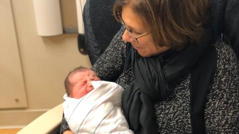 a grandmom sits with a newborn baby