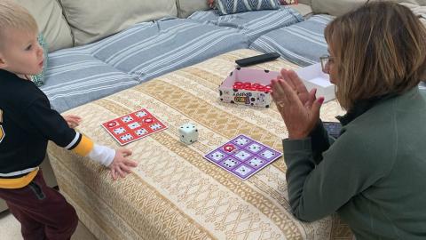 a young boy plays a memory board game with his grandmother