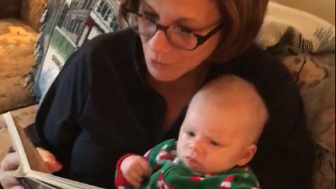 a grandmother reads to her infant grandchild