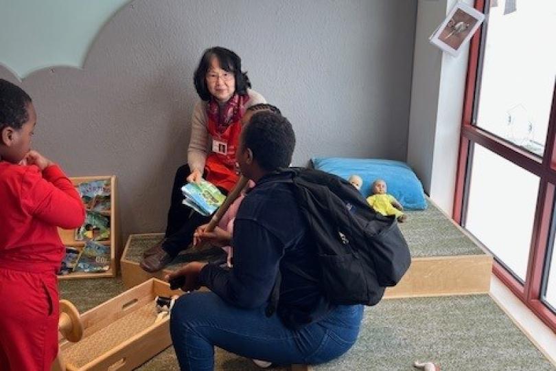 a grandparent staff volunteer speaks with parent visitors at a musum
