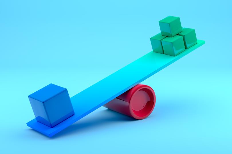 a lever is made out of a blue board resting on a round, red fulcrum, with a blue cube at one end of the leer and a pile of smaller green cubes at the other end