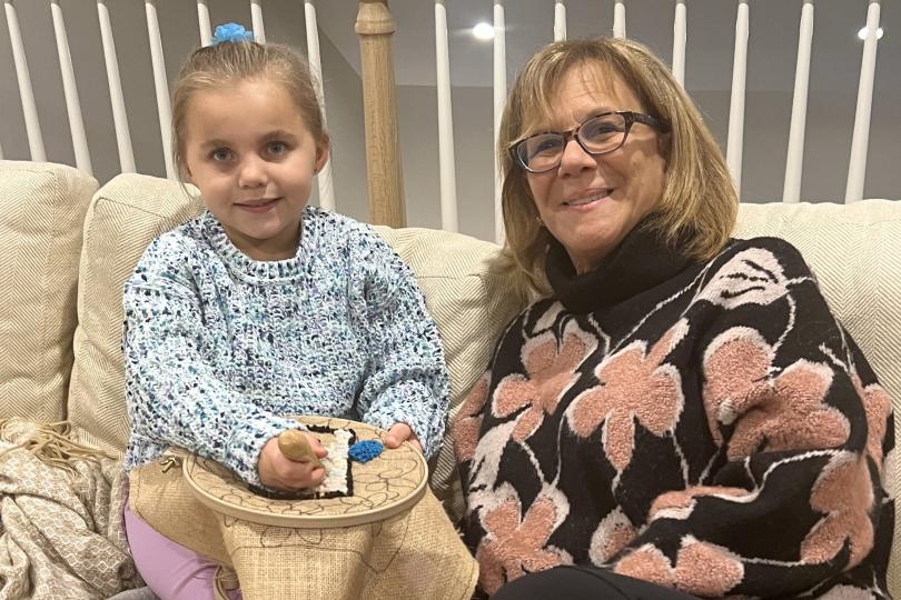 a grandmother and granddaughter work on a crafting project together