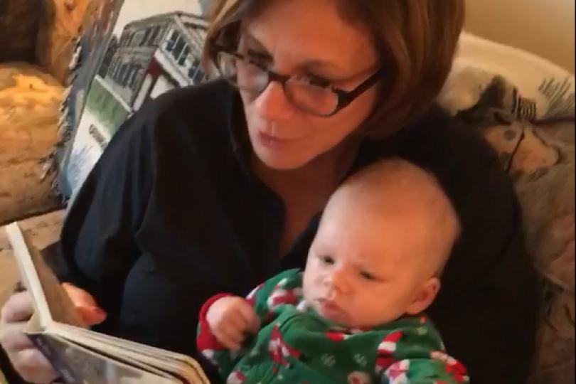 a grandmother reads to her infant grandchild