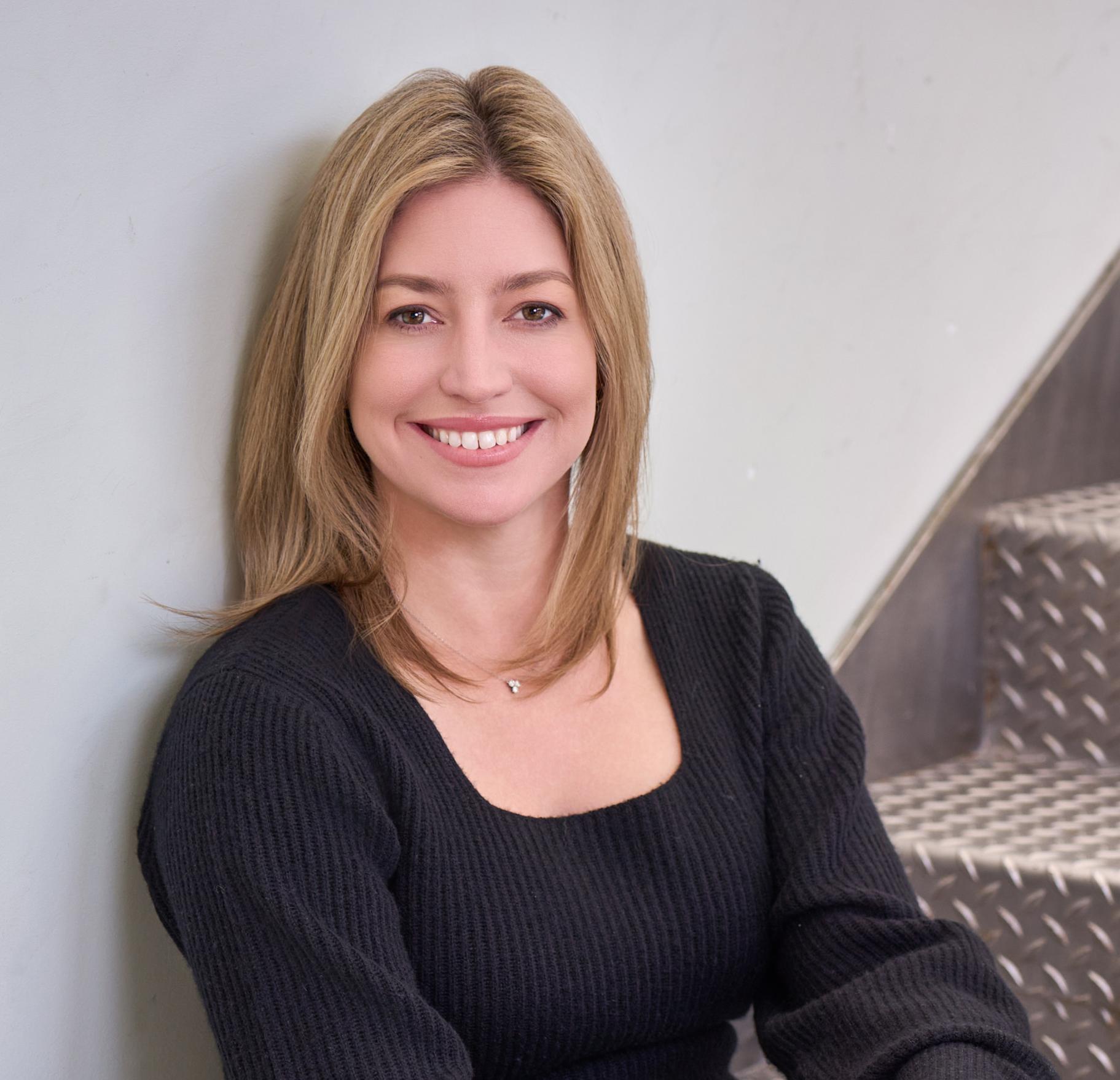 headshot of a woman sitting in stairs