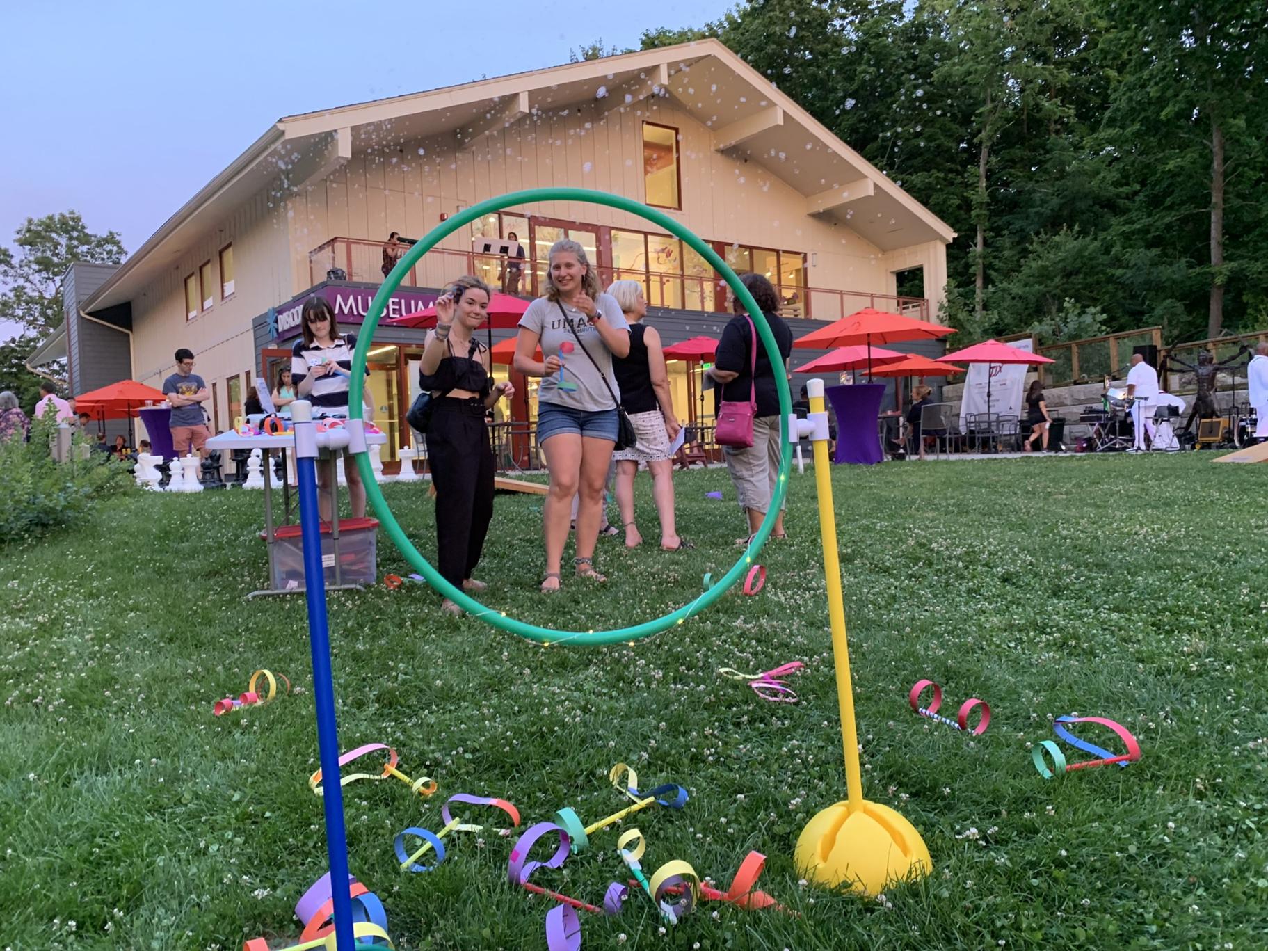 adults play a ring toss game outside