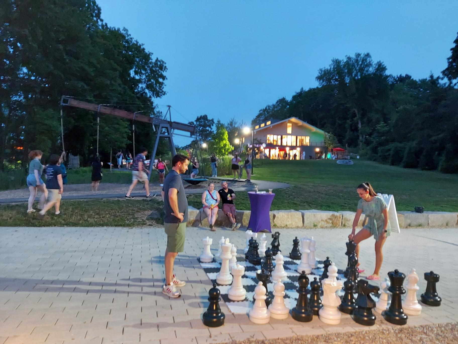 a couple plays outside with a giant chess set