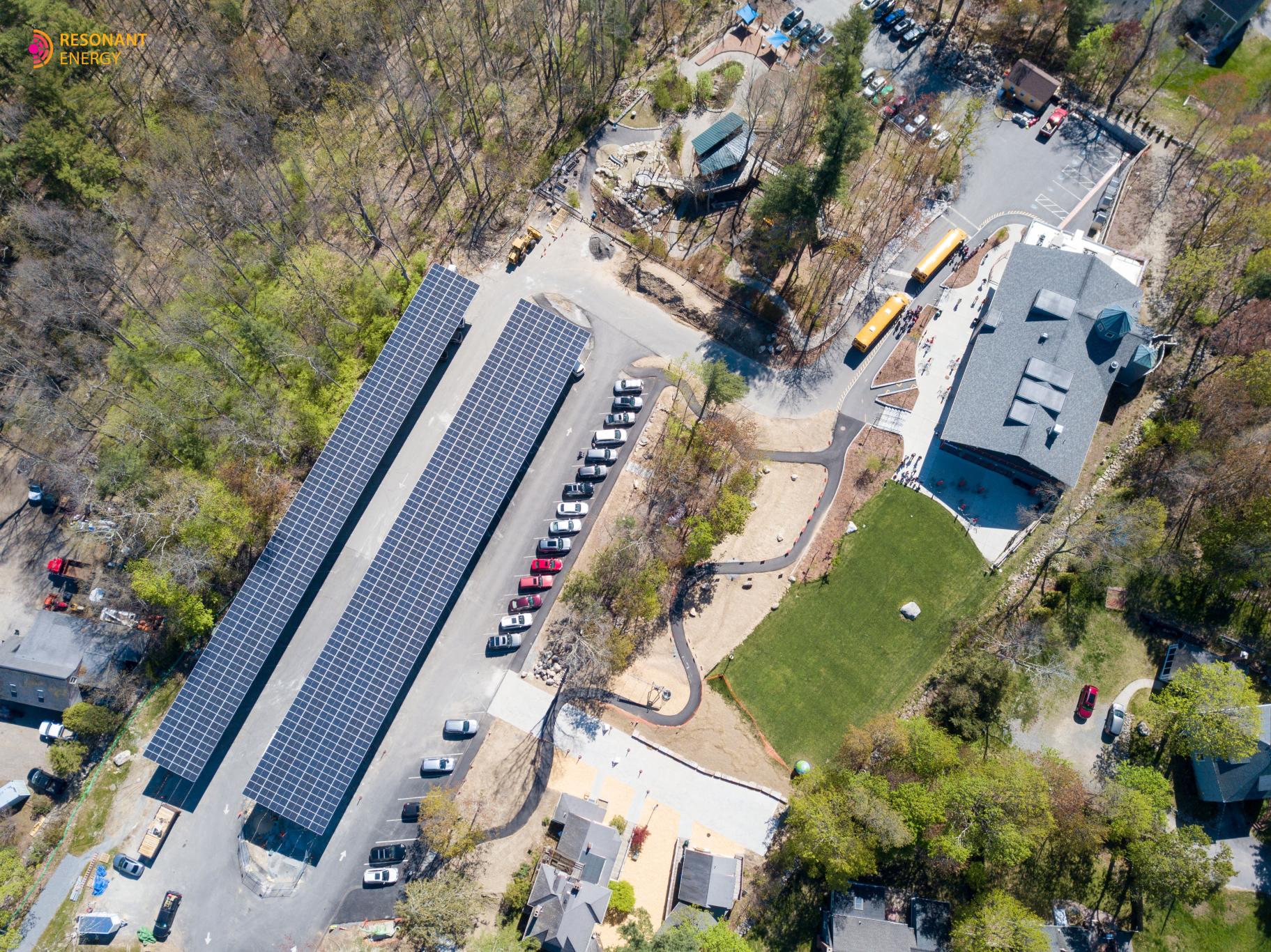 aerial view of Discovery Museum campus with two full rows of solar arrays on covered parking