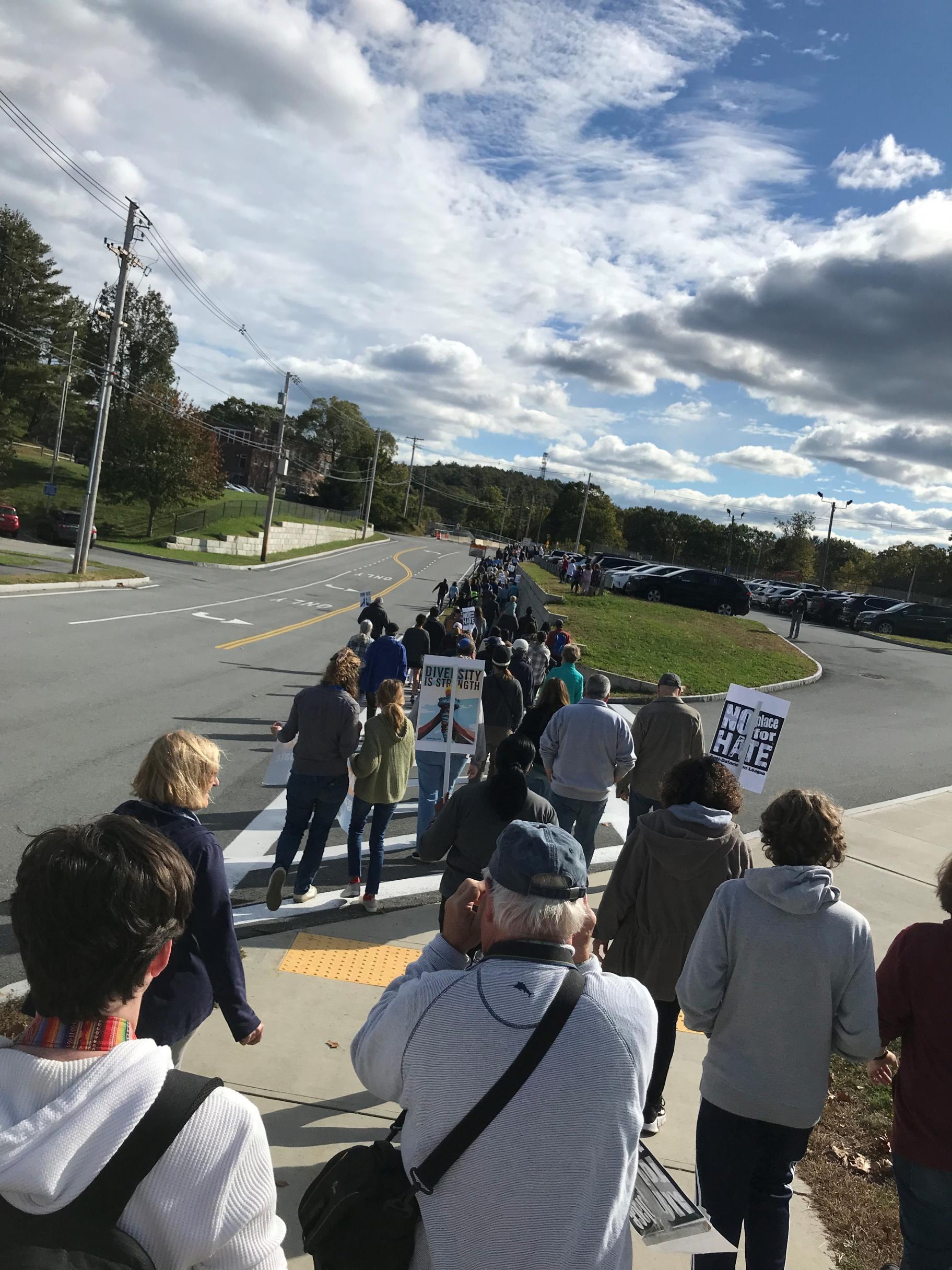 a group of people walk down a sidewalk